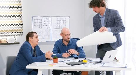 Els tres Co-CEOs de Quicktail reunits a l'oficina planificant l'estratègia de màrqueting, operacions i finances de l'empresa de cocteleria.